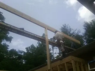 Carpenter setting a ridge beam over a new addition frame — Ice Dam Removal by Roofing Brothers in Percival