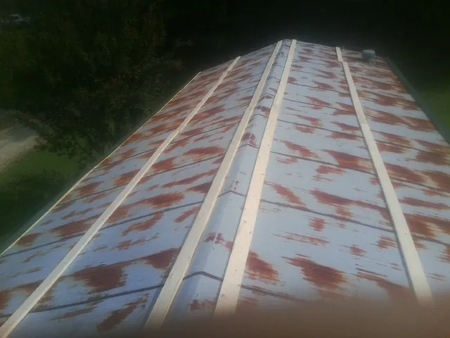 Rusted metal roof panels with new wood purlins before replacement — Storm Damage Roof Repair in Percival by Roofing Brothers