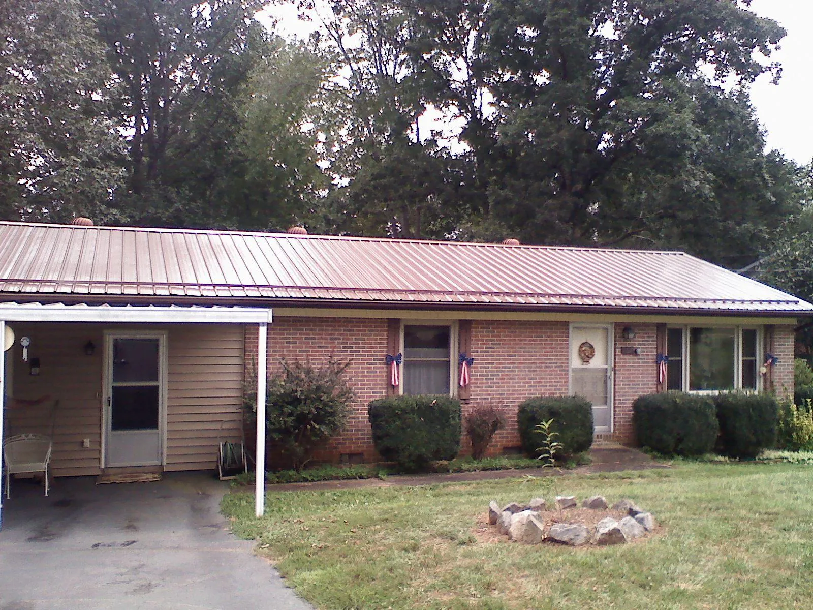 Bronze metal roof and carport on a brick ranch home — Roof Repair work by our crew in Percival